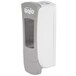 A grey and white GOJO® ADX-12 manual hand soap dispenser with a clear window on the box.