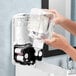 A person pouring GOJO foaming hand soap into a dispenser.
