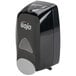 A GOJO® black manual hand soap dispenser with a clear plastic lid.