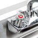 A close up of a chrome faucet with two red handles on an Eagle Group under bar sink.