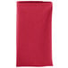 A folded hot pink Intedge cloth napkin on a white background.