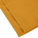 A folded gold cloth napkin.