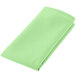 A folded seafoam green cloth napkin.