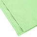 A folded seafoam green Intedge cloth napkin.