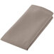 A folded beige Intedge cloth napkin.