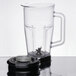 A clear plastic Waring blender jar with lid and blade.