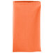 A folded orange Intedge cloth napkin.