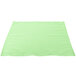 A seafoam green fabric napkin on a white surface.