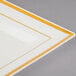 A Fineline plastic square plate in bone/ivory with a gold stripe on it.