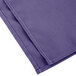 A purple Intedge cloth napkin with white edges folded.