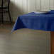 A table with a royal blue Intedge tablecloth and a plate on it.