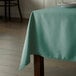 A table with a seafoam green Intedge rectangular tablecloth on it.