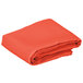 A folded orange cloth table cover on a white background.