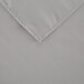A close up of a gray hemmed square polyester table cover.