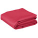 A stack of hot pink folded rectangular table covers.
