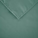 A seafoam green square fabric table cover with a folded edge.