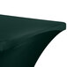 A hunter green Snap Drape contour table cover on a table with a curved edge.