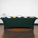 A table with a hunter green Snap Drape spandex table cover with bowls of food on it.