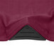 A close up of a burgundy Snap Drape spandex table cover corner.