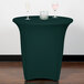 A hunter green Snap Drape spandex table cover on a table with a wine glass.