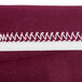 A burgundy spandex table cover with a white zipper.