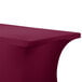 A burgundy Snap Drape Contour Table Cover with curved edges on a table.