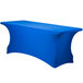 A royal blue Snap Drape Contour Spandex table cover with a curved edge on a table.