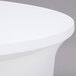 A white Snap Drape spandex table cover on a round table.