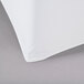 A white spandex table cover with a contour fit.