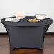 A charcoal Snap Drape spandex table cover on a table with plates of food.