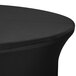A black Snap Drape Contour spandex table cover with a round edge on a table.