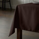 A brown Intedge tablecloth on a wooden table.