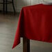 A square red Intedge tablecloth on a table.