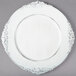 A white Charge It by Jay plastic charger plate with a decorative border.