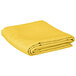 A yellow rectangular cloth table cover folded on a white background.