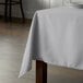 A table with a gray Intedge rectangular tablecloth on it.