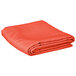 An orange Intedge rectangular cloth table cover folded up on a white background.
