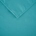 A teal 100% polyester hemmed cloth table cover with a folded edge.