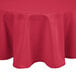 A hot pink polyester round table cover on a table.