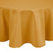 A round table with a gold Intedge tablecloth on top.