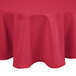 A hot pink polyester round tablecloth on a table.