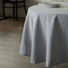 A table with a gray Intedge round tablecloth and a plate on it.