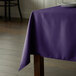 A purple Intedge square table cloth on a table.