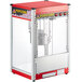 A red and white Carnival King popcorn machine with a glass top.