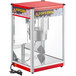A red and silver Carnival King popcorn machine with a clear glass front.