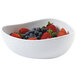 A white GET Coralline melamine triangle bowl filled with strawberries and blueberries.