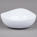A white melamine triangle bowl with a wavy design.