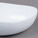 A close up of a white Coralline triangle bowl with a pattern on it.