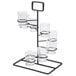 A black metal GET Tower Dessert Shot Display Stand holding six clear glasses with black bands.