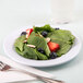 A Minski white melamine plate with a salad of strawberries, blueberries, and spinach.